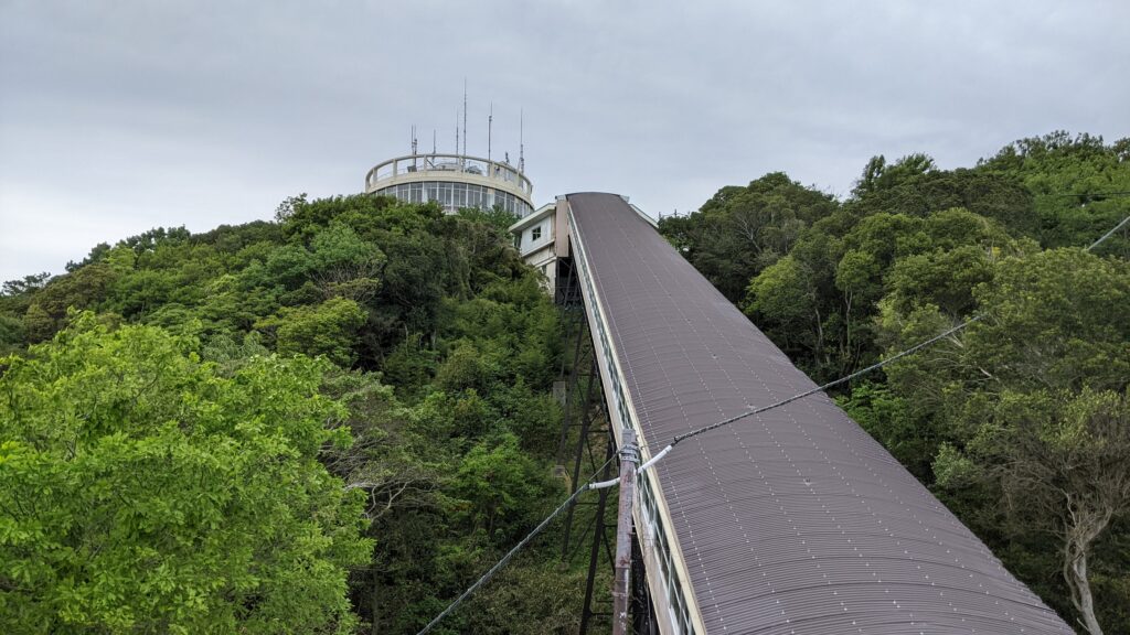 A nostalgic view of the Carlator leading to the revolving observatory in Sumaura Park, Kobe. The lush greenery and retro transport inspire the "slow time" rhythm of the kodiad Kobe art project.
