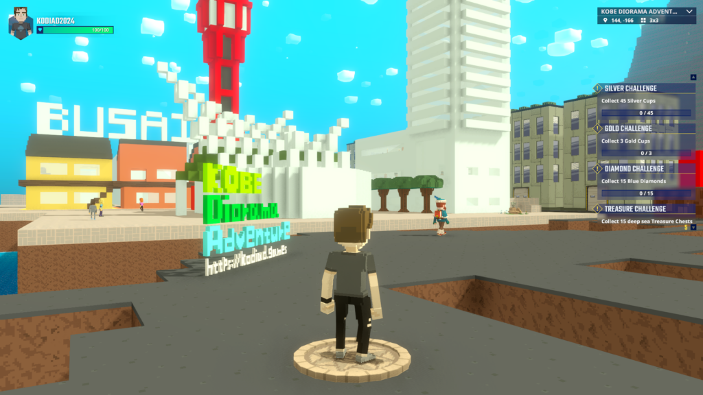 A voxel character standing at the new spawn point in KOBE Diorama Adventure. A colorful "KOBE Diorama Adventure" sign and the red Port Tower are visible, welcoming players to the experience.