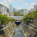 A professional Kobe art piece showcasing Shin-Kobe Station as an urban oasis where nature and high-rise apartments coexist, capturing the Scent of Memory for the Kobe Metaverse.